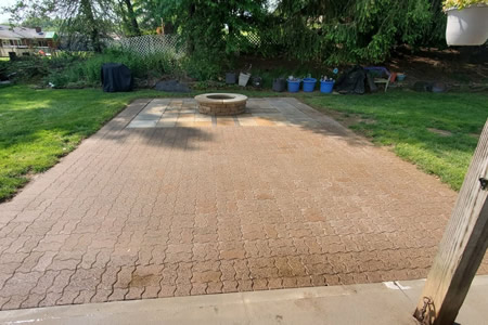 Technician sealing patio pavers in bethel home backyard